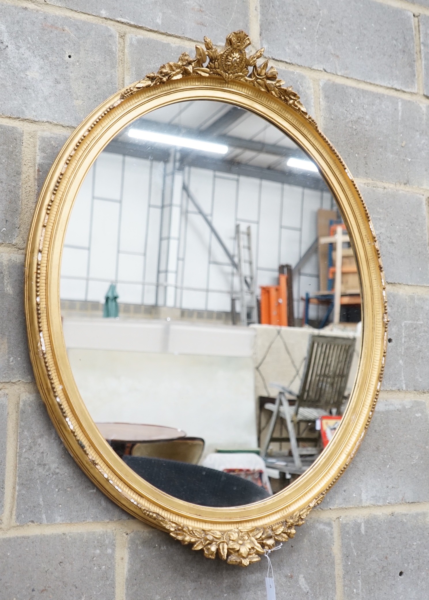 An early 20th century gilt wood and gesso oval wall mirror width 75cm height 96cm.